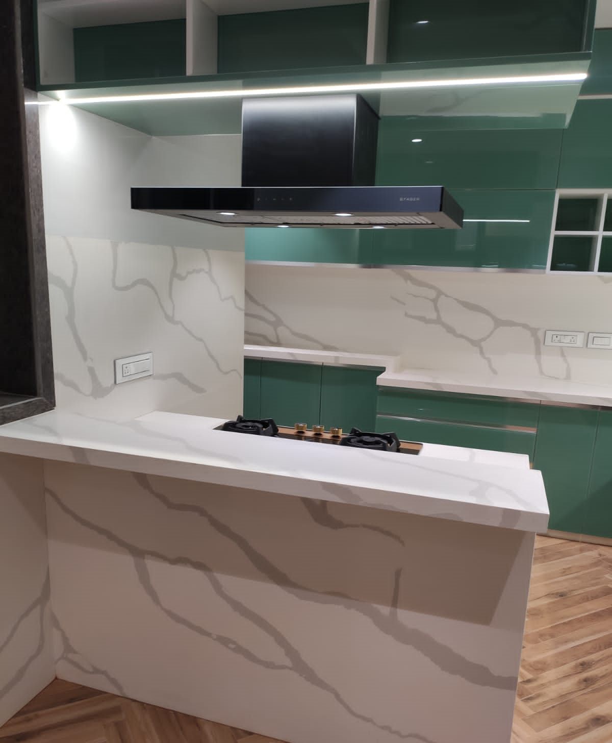 Marble-look island with built-in hob in the emerald glass kitchen