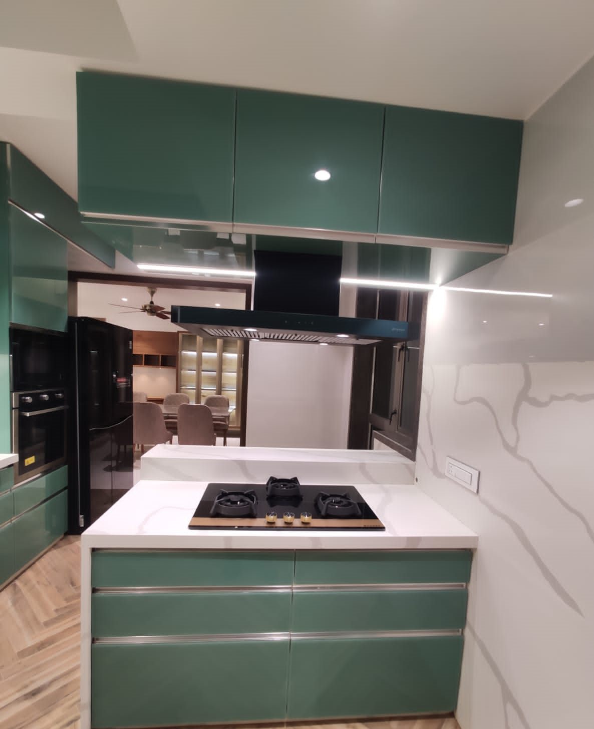 Island hob with chimney beside the tall appliance unit