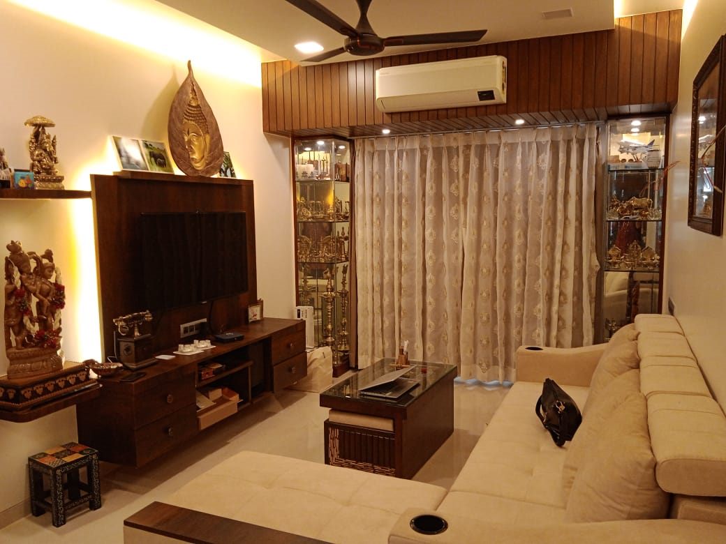Living room with walnut TV unit, display cabinets and a cove-lit false ceiling