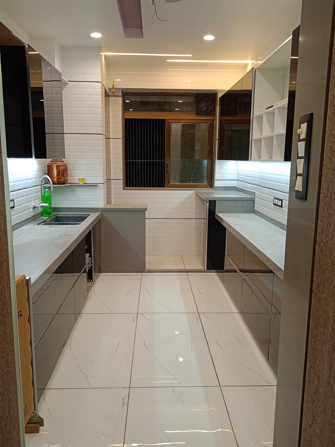 Parallel kitchen with grey and white back-painted glass shutters and open shelving