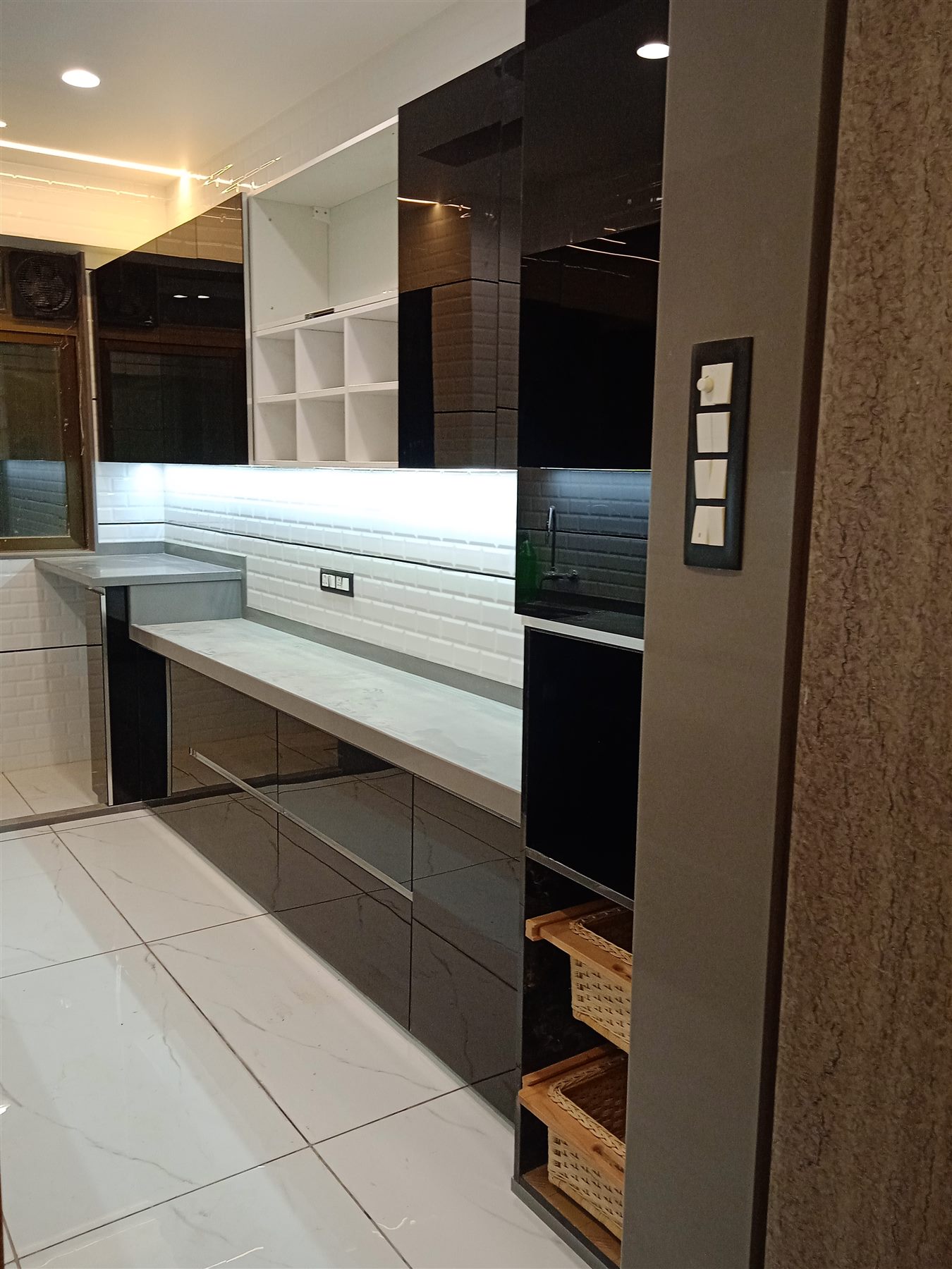 Back-painted glass wall units above a grey counter run